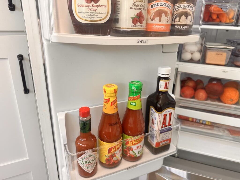 Refrigerator organization,Fridge organization - Kitchen Fridge door shelf with Tabasco, taco sauces, A.1. steak sauce, and sweet syrups above.