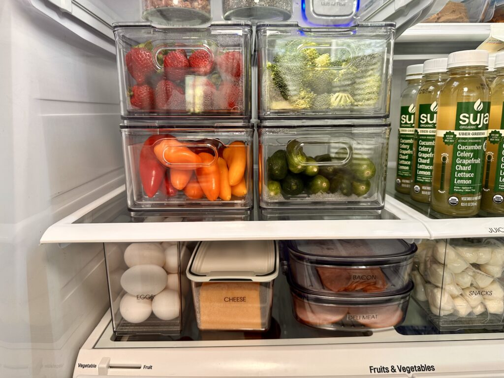 Refrigerator organization,Fridge organization - Kitchen Close-up of fridge shelf with organized produce bins, eggs, cheese, deli meat, and green juice bottles.