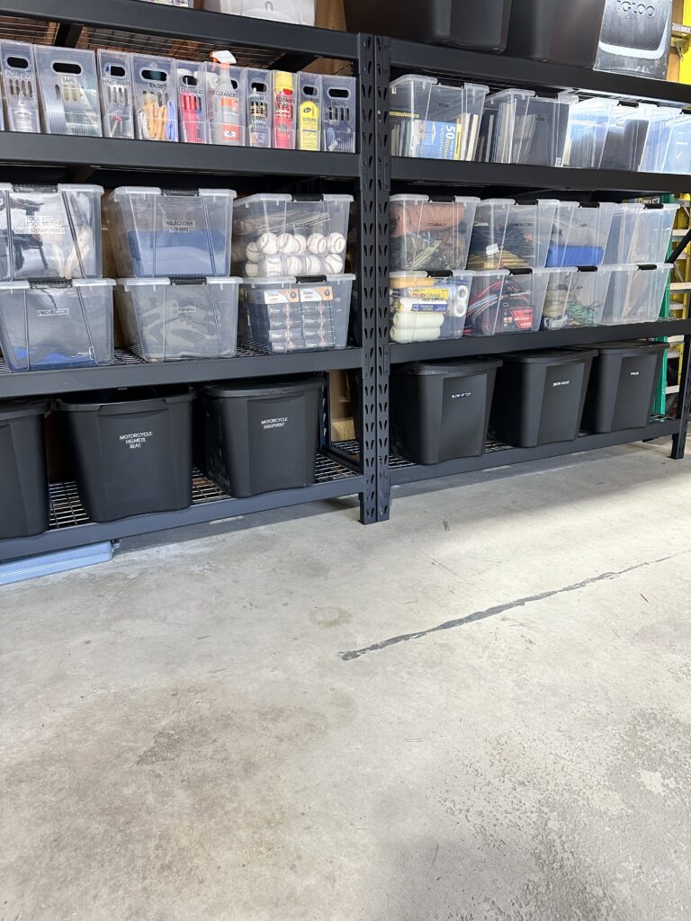 Organized garage with storage cabinets, shelving, and neatly arranged equipment