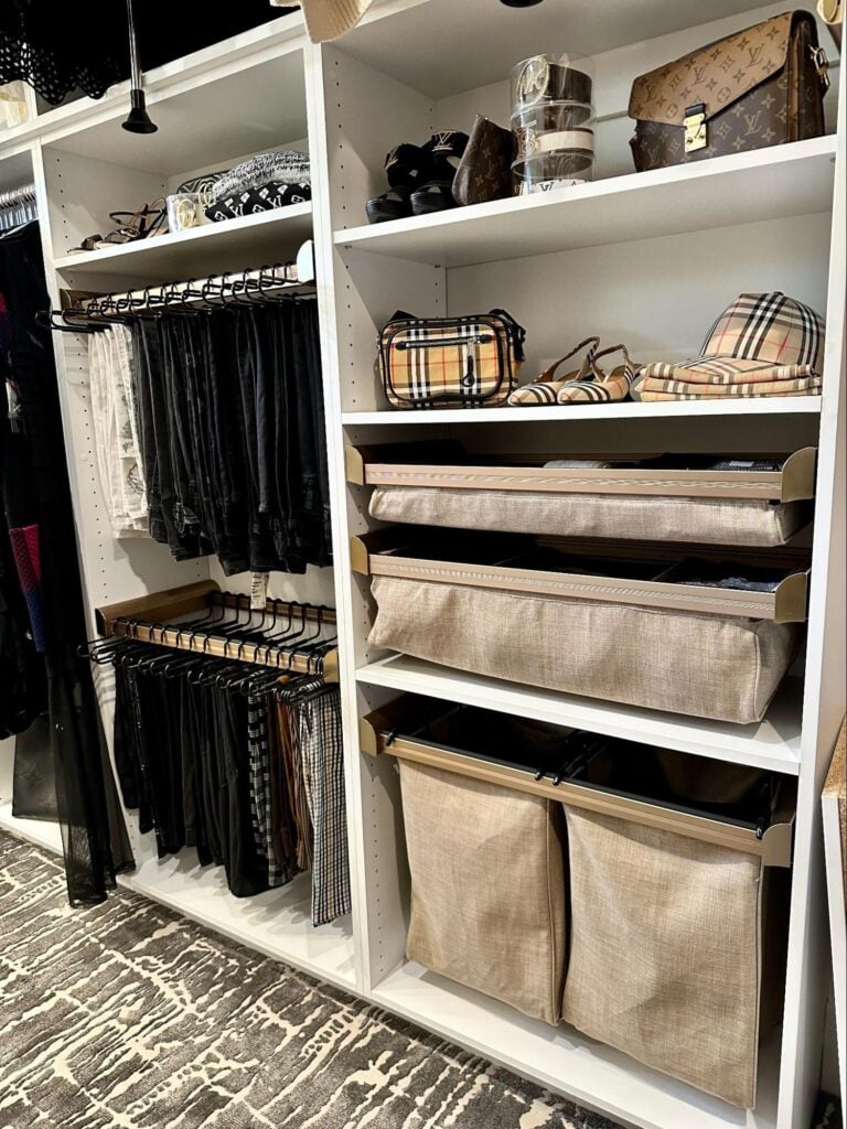 Walk-in closet with shelves, drawers, and bins neatly organizing clothing and accessories.