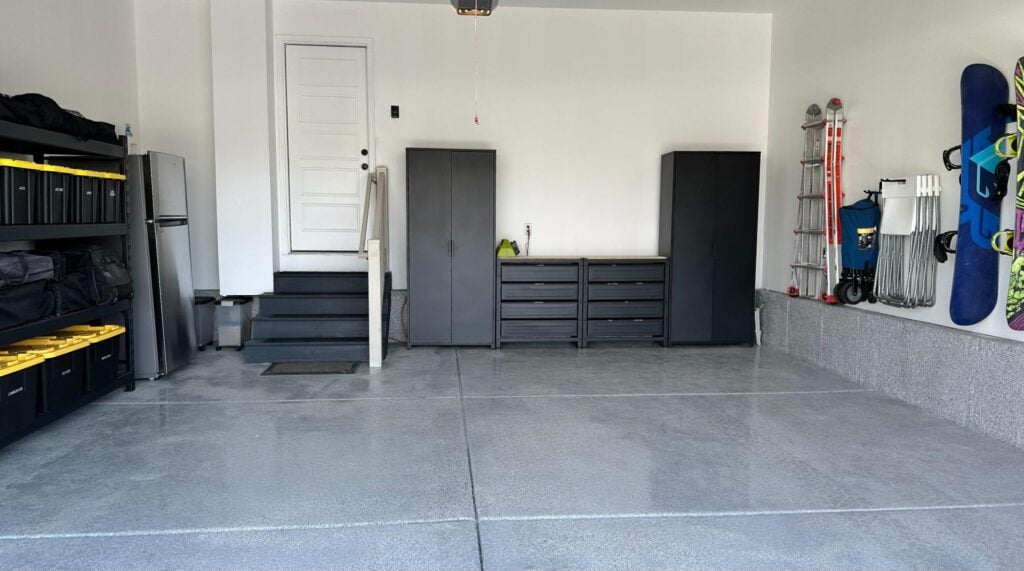 Organized garage with storage cabinets, shelving, and neatly arranged equipment.