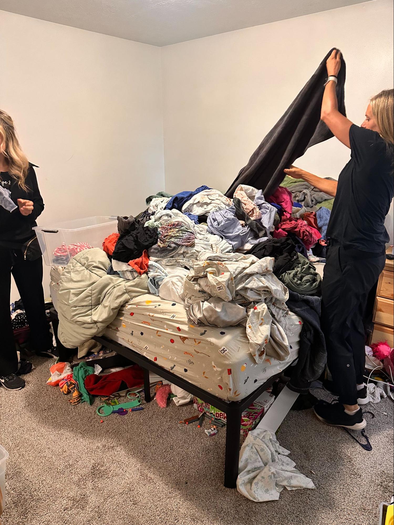 Two organizers sorting a large pile of clothes