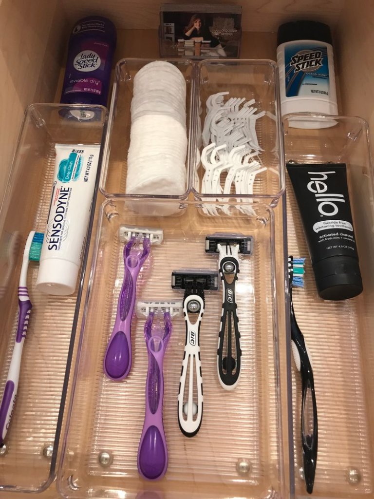 Bathroom organization ideas - Home Organization Organized bathroom drawer with clear bins holding toothbrushes, toothpaste, razors, floss picks, and deodorant