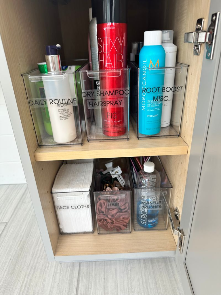 Bathroom organization ideas - Home Organization Bathroom cabinet shelves organized with hair products, sprays, skincare items, and clear storage bins
