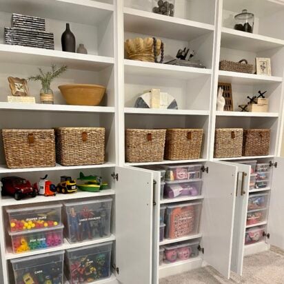 Built-in shelving with labeled baskets and clear bins organizing toys and kids’ items