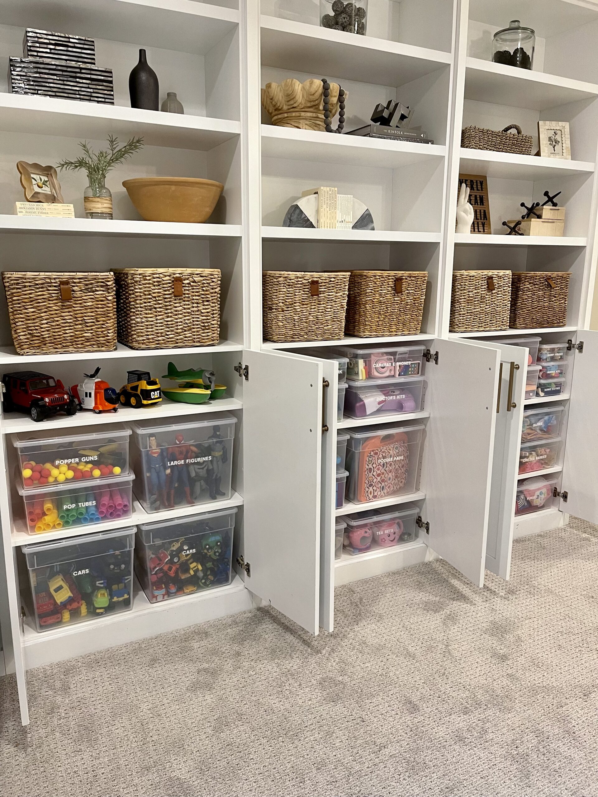 Built-in shelving with labeled baskets and clear bins organizing toys and kids’ items