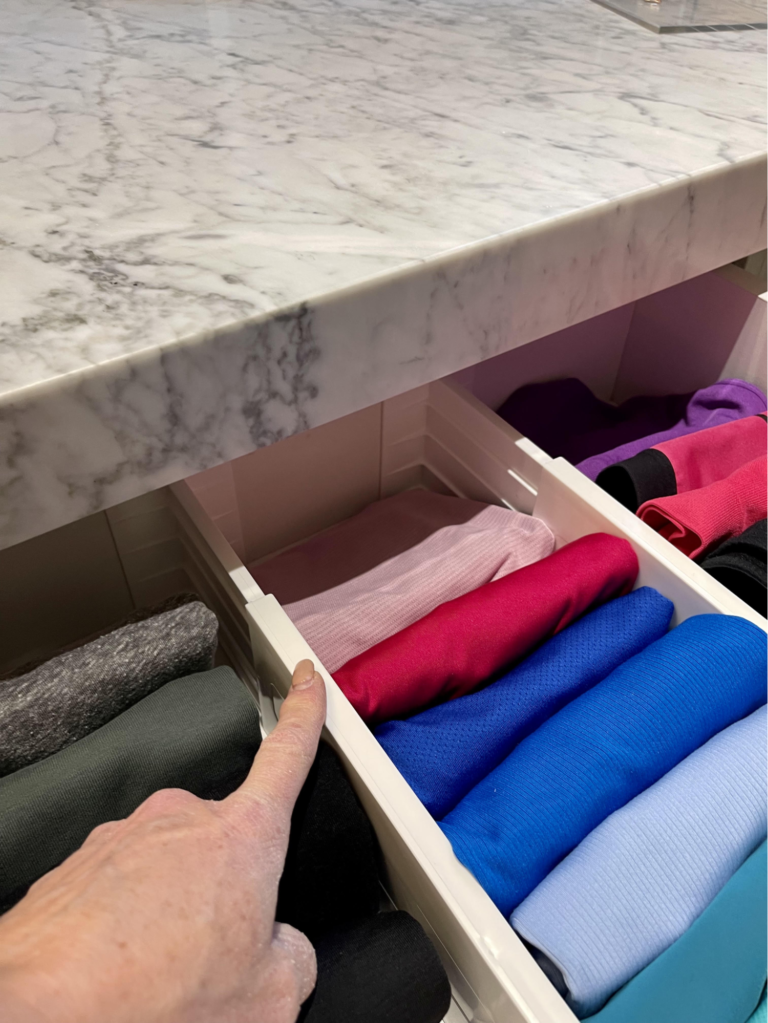 Drawer dividers separating folded clothing by color, creating an organized and easy-to-use storage system