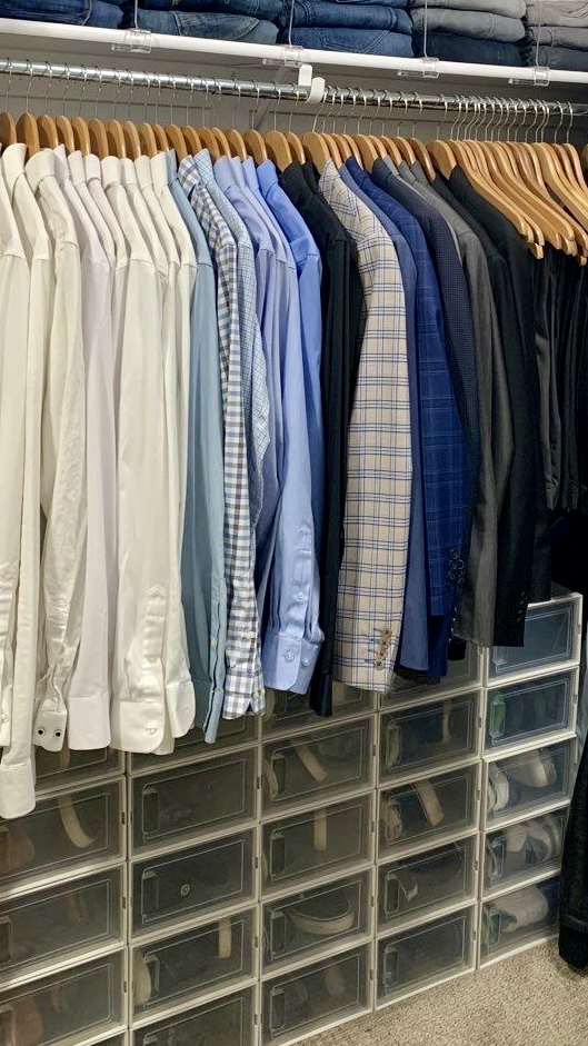 Organized closet with neatly hung shirts on wooden hangers and labeled drawers creating a clean, functional storage system