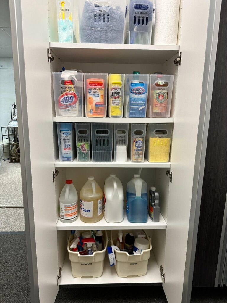 Spring cleaning checklist - Home Organization Organized cleaning supply cabinet with labeled bins and bottles neatly arranged on shelves