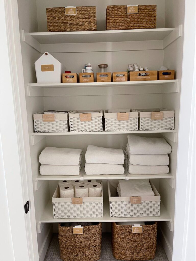 linen closet organization - Home Organization Neatly organized linen closet with labeled baskets, folded towels, and bathroom essentials on clean white shelves
