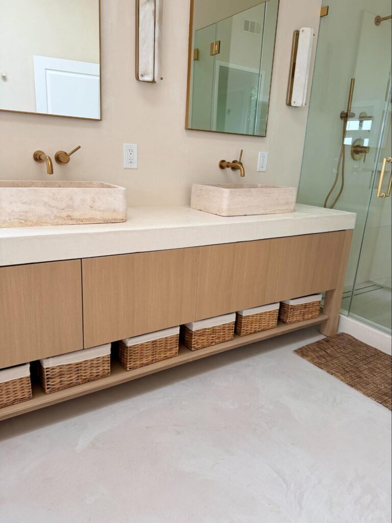 Spring cleaning checklist - Home Organization Modern bathroom vanity with double sinks, woven storage baskets, and glass shower