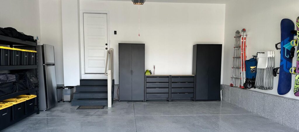 Organized garage with wall storage, cabinets, shelving, and labeled bins