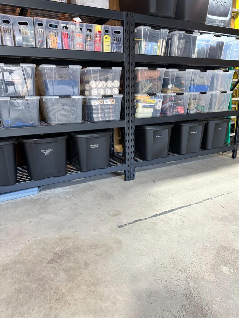 Garage shelving with clear storage bins and labeled black containers