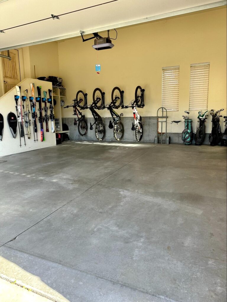 Garage with wall-mounted racks storing bikes, skis, and gear