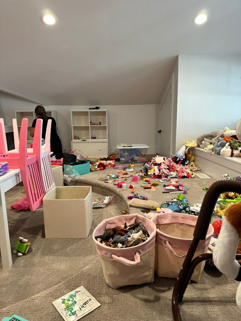 Toy rotation ideas - Kids bedroom organization Playroom decluttering process with toys spread across the floor before organizing storage bins and shelves.