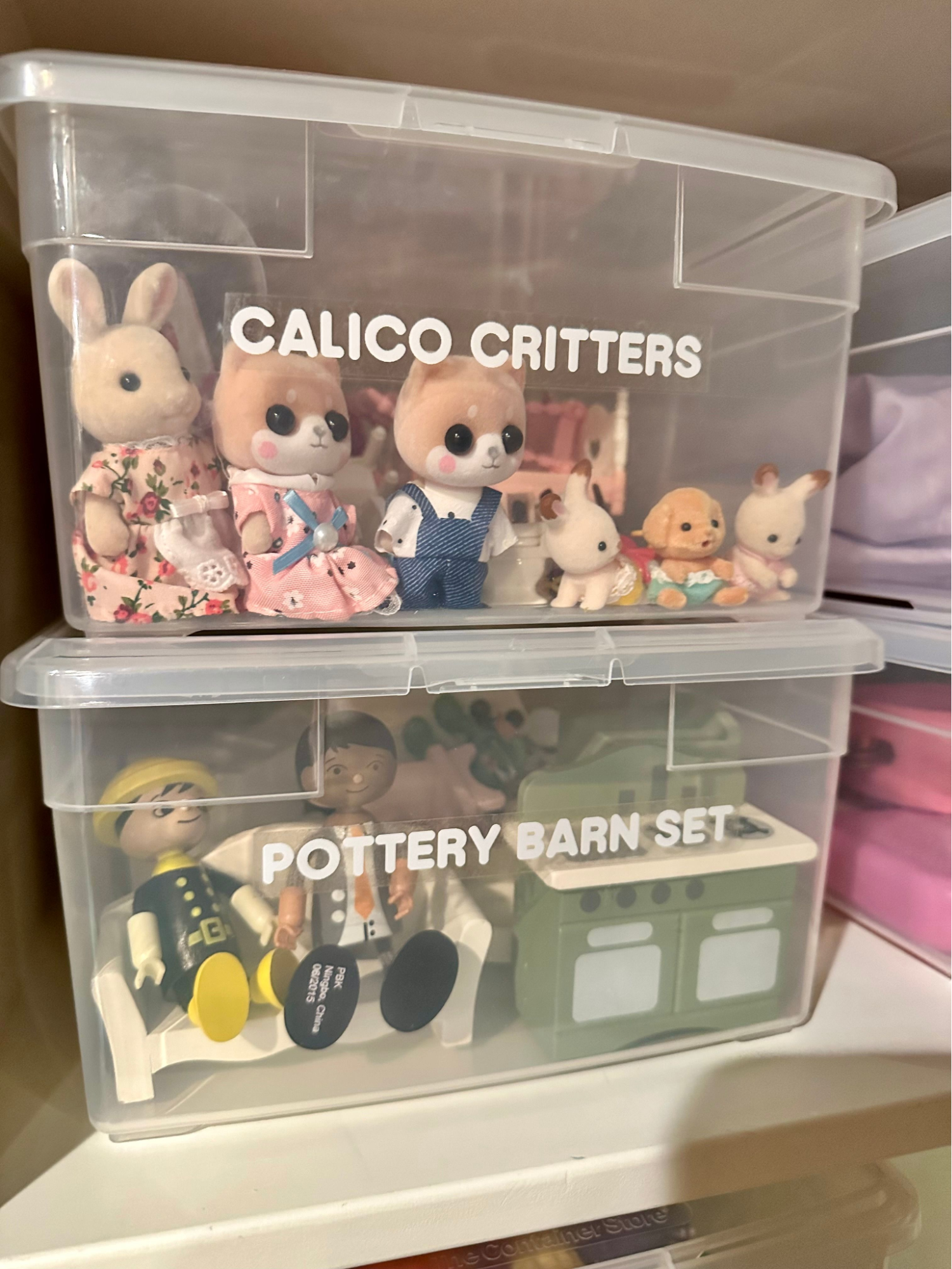 Toy rotation ideas - Kids bedroom organization Clear storage bins with Calico Critters toys and dollhouse play sets organized on shelving.