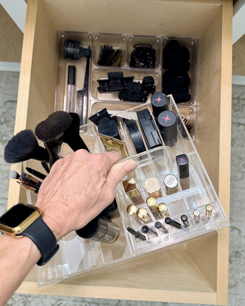 Bathroom makeup drawer organized with clear acrylic dividers