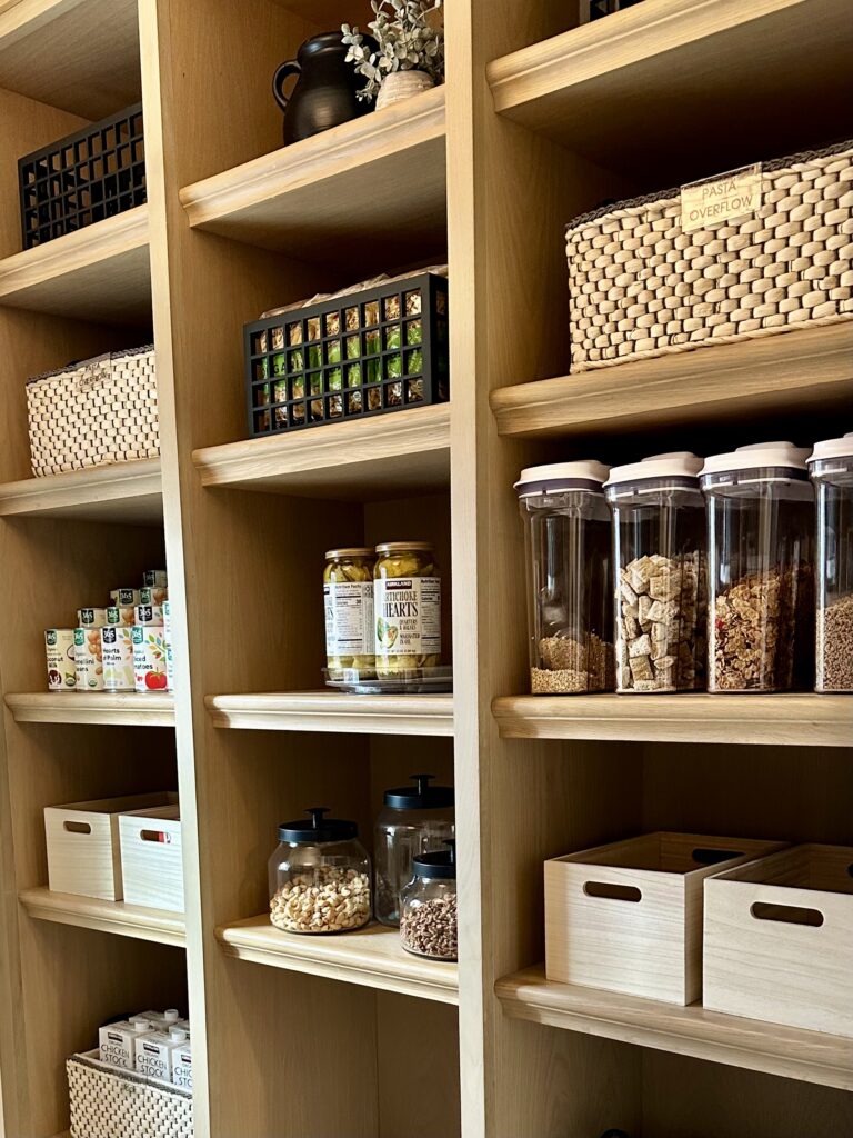Pantry shelves with labeled containers, baskets, and organized food storage