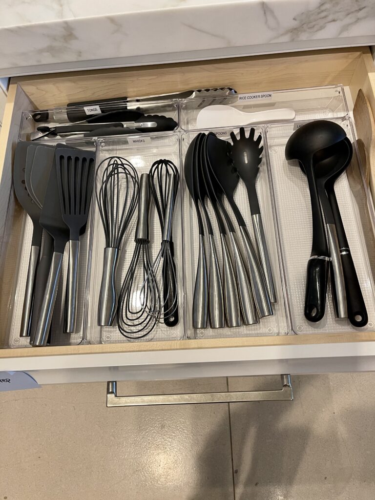 Kitchen utensil drawer organized with labeled compartments