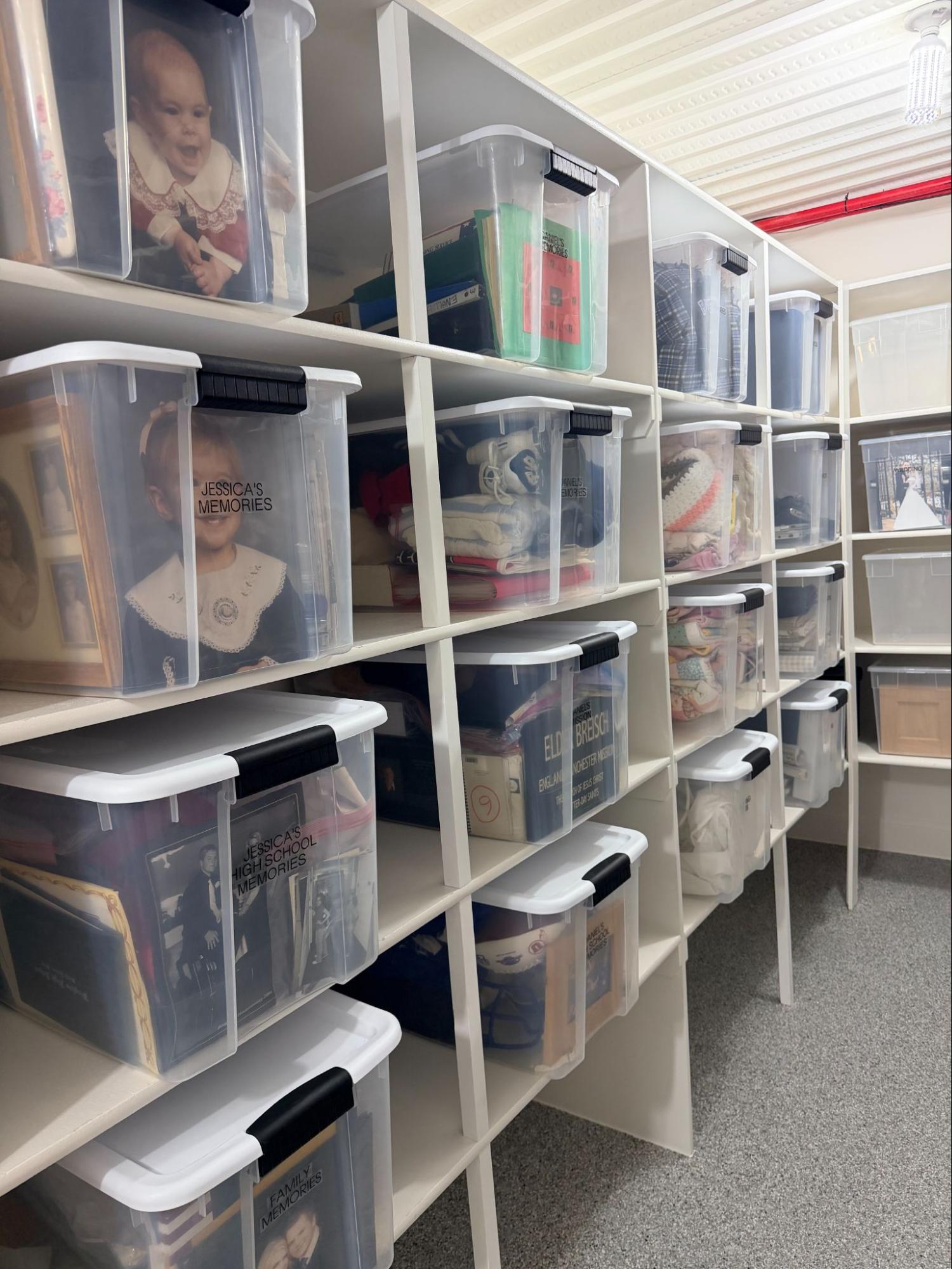 Labeled family memory bins organized on storage room shelves