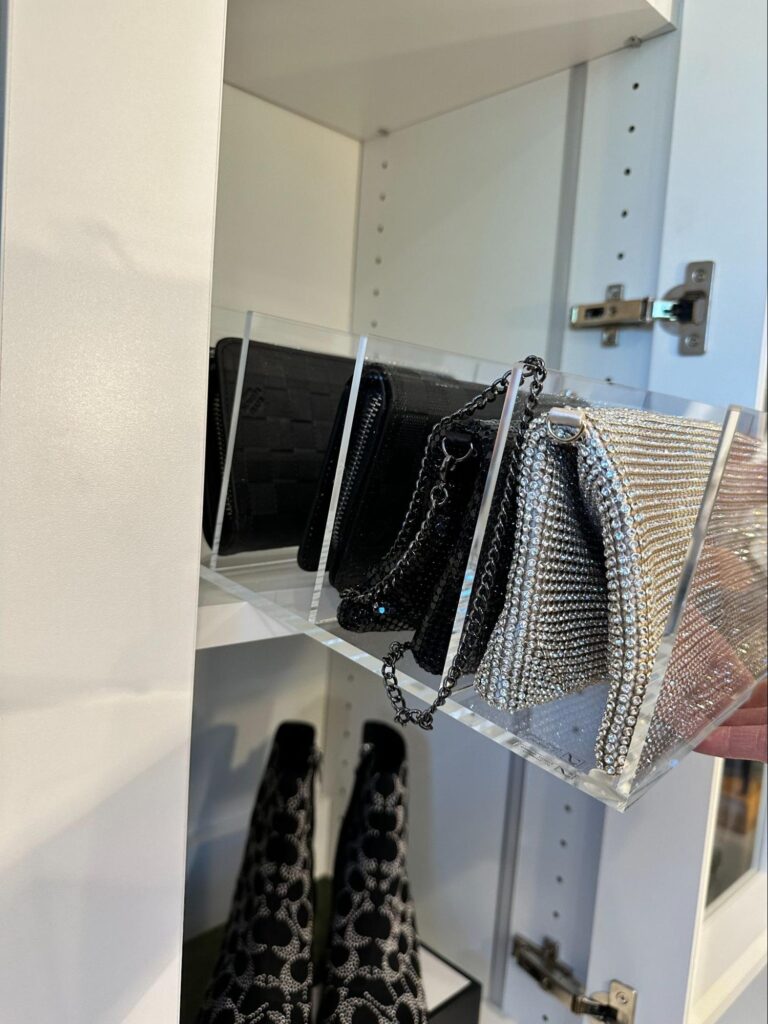 walk in closet organization - Closet Organization Clear acrylic shelf dividers keeping designer handbags upright and separated inside a white closet cabinet.