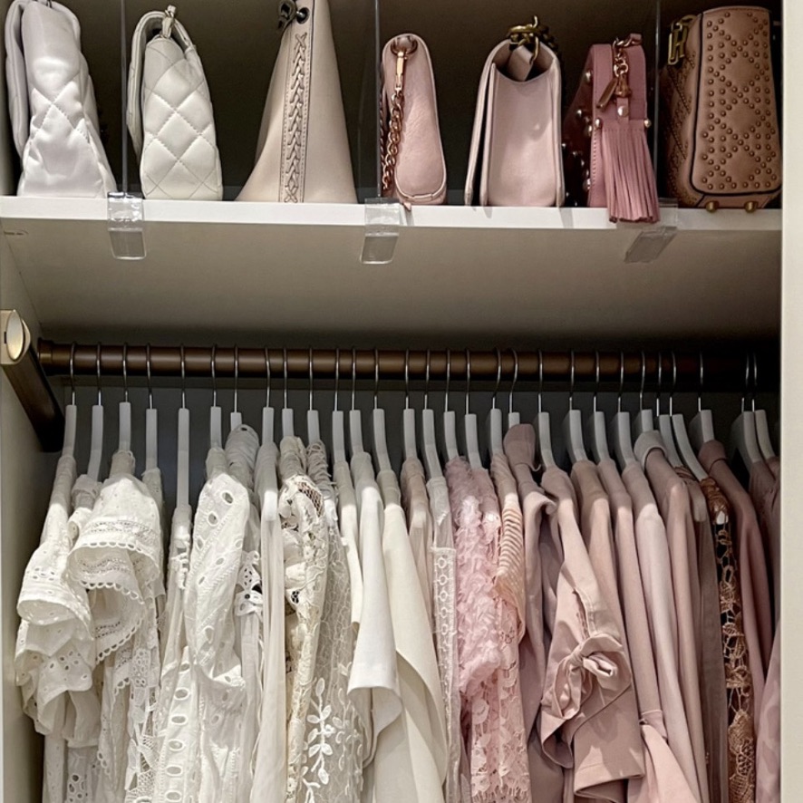 walk in closet organization - Closet Organization Walk-in closet with white and pink clothing arranged by color beneath a shelf of coordinating handbags.