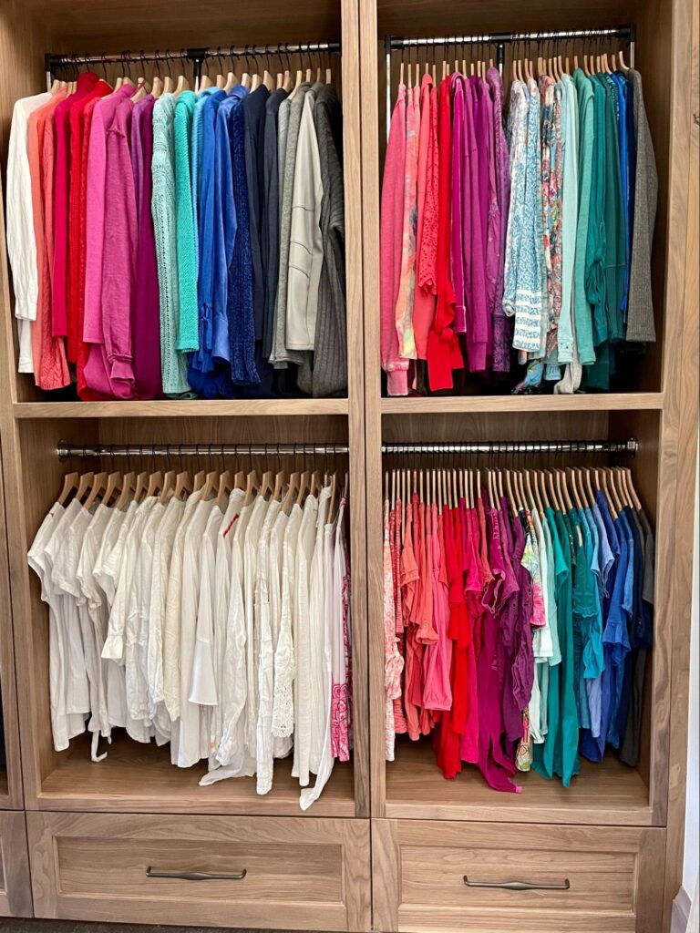 walk in closet organization - Closet Organization Color-coded walk-in closet with shirts arranged in rainbow order on double hanging rods above wooden drawers.